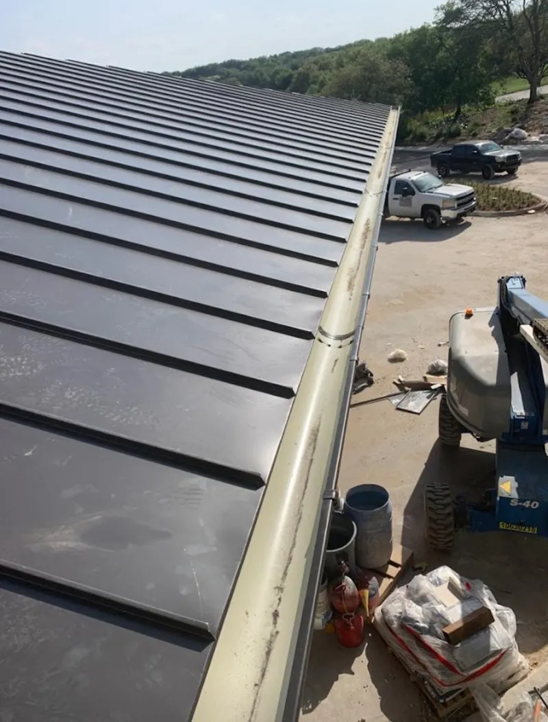 Standing seam panel and gutter detail on a metal roofing jobsite in Cibolo